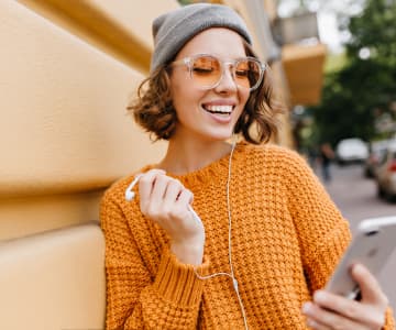 Woman smiling and holding a tablet with an online course interface
